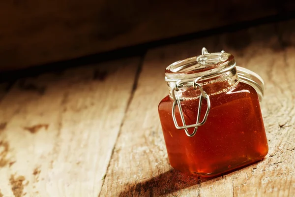Ravgul mørk honning i en glaskrukke - Stock-foto