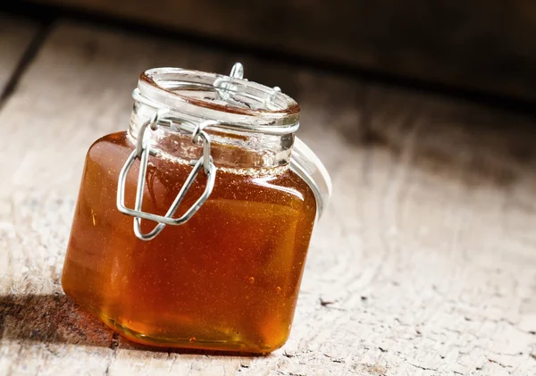 Amber dark honey in a glass jar — Stock Fotó