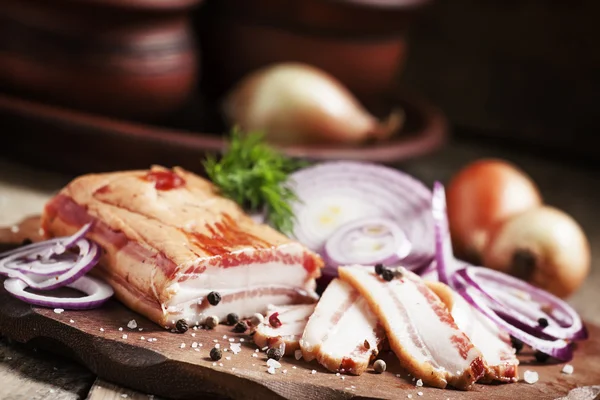Panceta ahumada, cebolla roja, sal y pimienta en un plato de barro —  Fotos de Stock