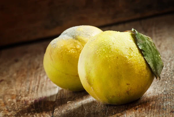 Rijpe kweepeer fruit is op een oude houten tafel in rustieke stijl — Stockfoto