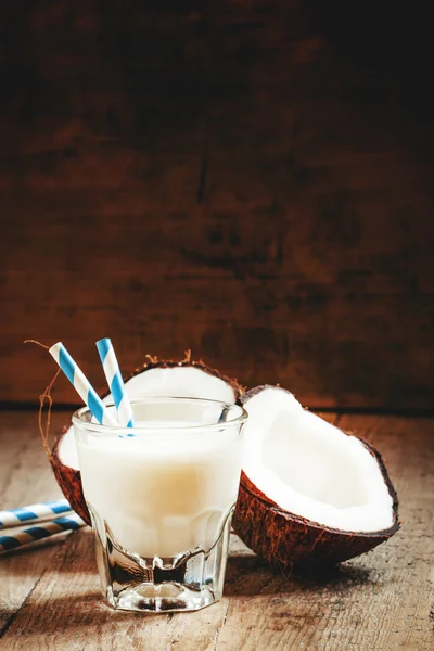 Stock image Coconut milk in a glass with striped straws and coconut halves