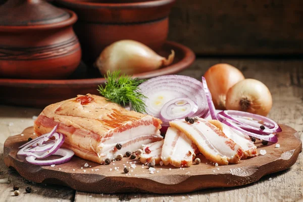 Smoked bacon, red onion, salt and pepper on a clay dish — 图库照片