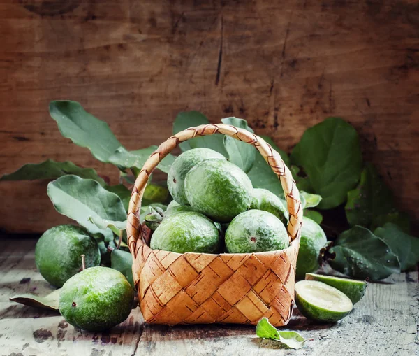 Ripe green feijoa fruits with leaves in a wicker basket — 图库照片