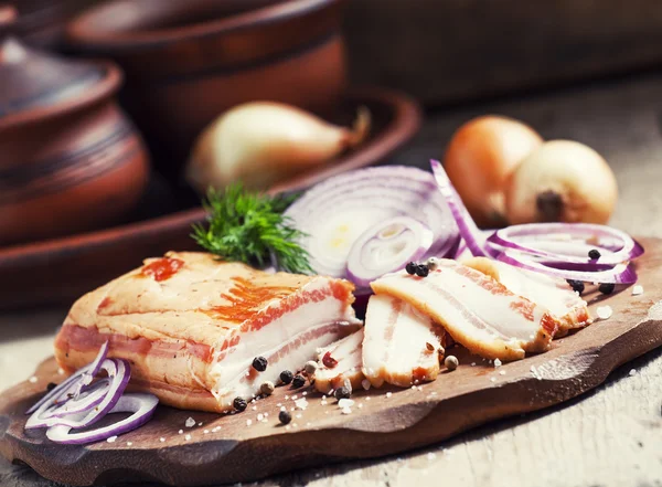 Smoked bacon, red onion, salt and pepper on a clay dish — 图库照片