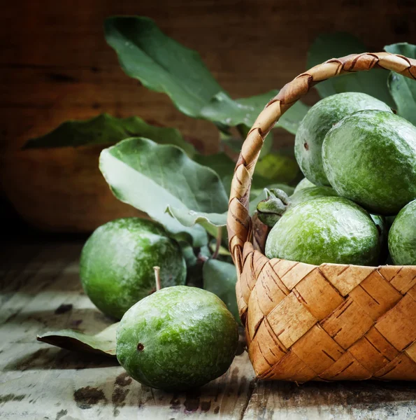 Ripe green feijoa fruits with leaves in a wicker basket — 图库照片