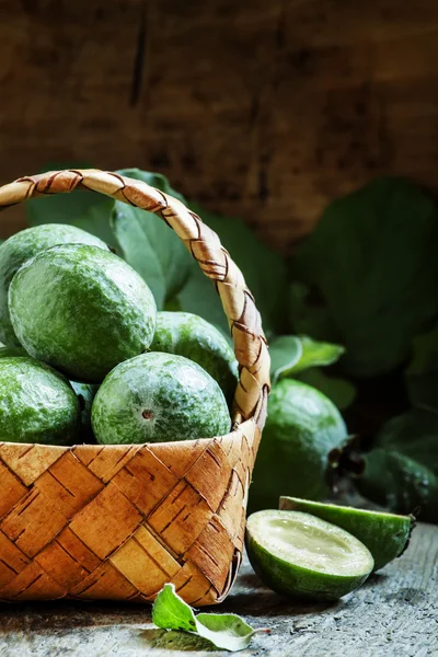 Спелые зеленые фрукты фейхоа с листьями в плетеной корзине — стоковое фото