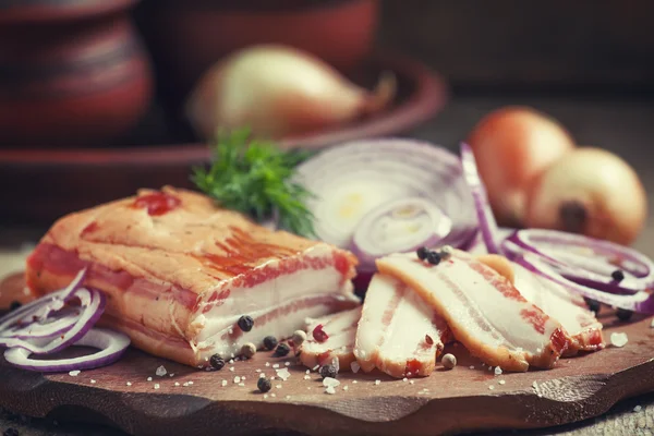 Bacon defumado, cebola vermelha, sal e pimenta em um prato de barro — Fotografia de Stock