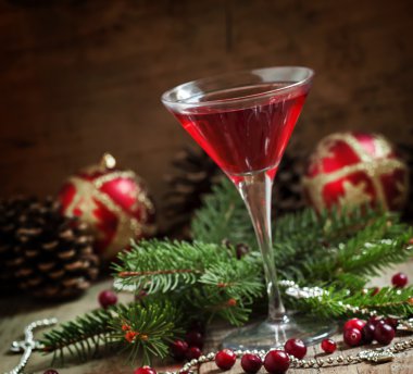 Red Christmas cocktail in a martini glass with fir branches