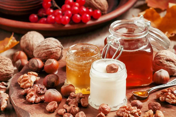 Three types of honey with walnuts and hazelnuts — Stock Photo, Image