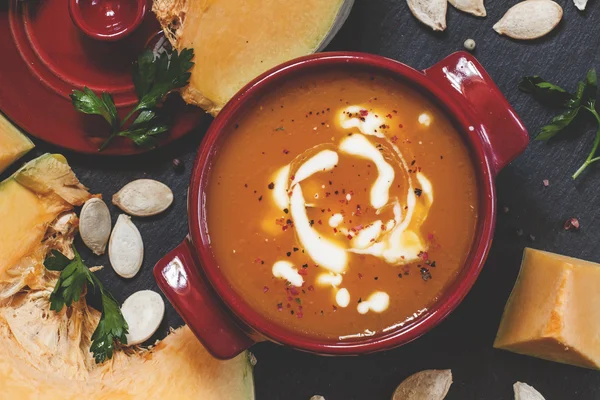 Pumpkin soup with sour cream in a saucepan — Stok fotoğraf