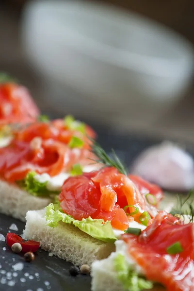 Small sandwiches with salty salmon,  soft cheese and green salad — Stock Photo, Image