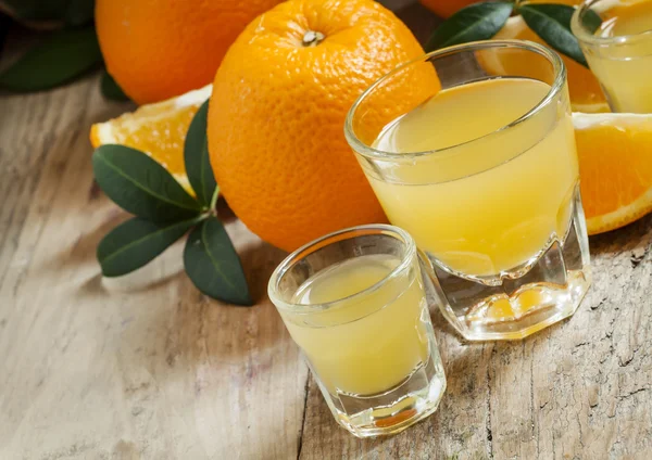 Jus d'orange frais dans un grand et un petit verre — Photo