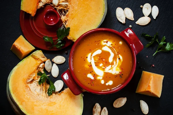 Pumpkin soup with sour cream in a saucepan — Stock Image Pumpkin soup with sour cream in a saucepan Royalty Free Stock Images