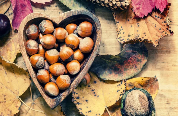 Nocciole fresche in una ciotola di legno nella forma di cuore — Foto Stock