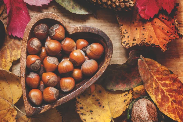 Nocciole fresche in una ciotola di legno nella forma di cuore — Foto Stock