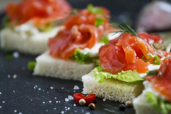 Small sandwiches with salty salmon, soft cheese and green salad — Stock Image Small sandwiches with salty salmon, soft cheese and green salad Stock Image