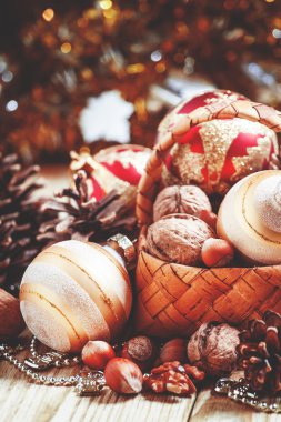 Çam kozalakları, fındık, Noel topları, tinsel ve boncuk ile hasır sepet