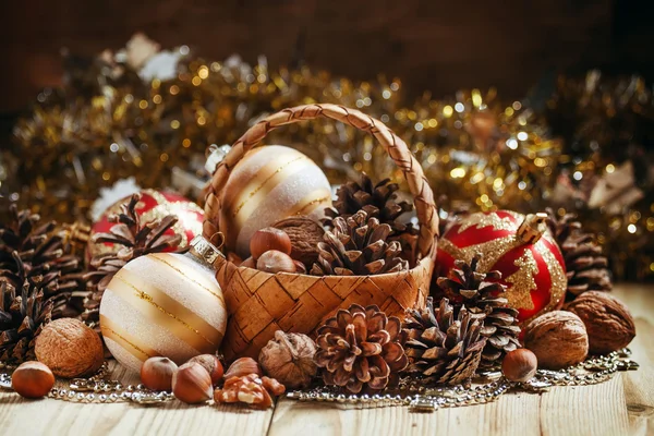 Cesta de vime com cones de abeto, nozes, bolas de Natal, ouropel e contas — Fotografia de Stock