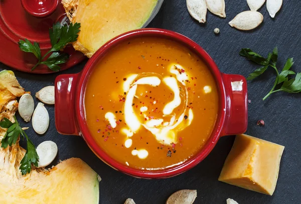 Pumpkin soup with sour cream in a saucepan — Stok fotoğraf