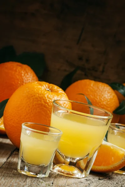 Свіжий апельсиновий сік у великих і маленьких склянках — стокове фото