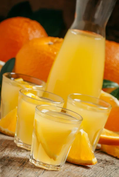 Succo d'arancia con pezzi di frutta in piccole tazze e una brocca — Foto Stock