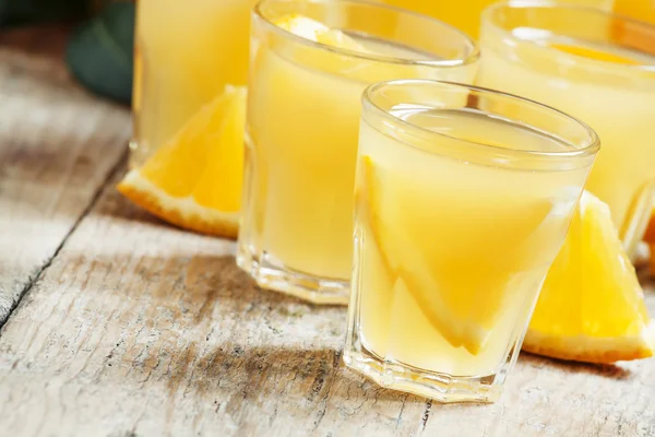 Jugo de naranja con trozos de fruta en tazas pequeñas y una jarra —  Fotos de Stock