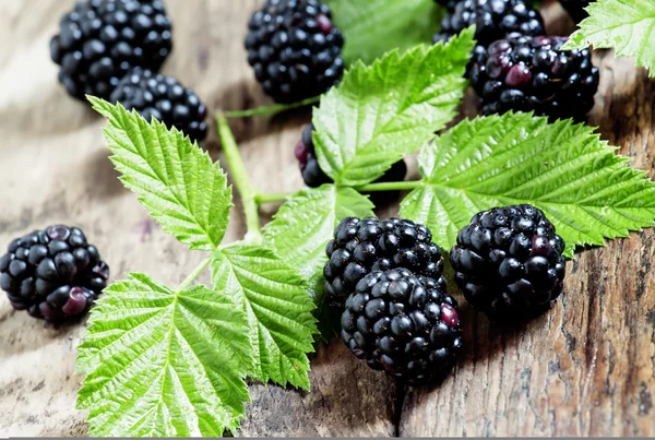 Frische Brombeeren mit Blättern auf dem alten Holzgrund — Stockfoto