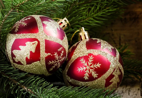 Dvě červené a zlaté vánoční koule a smrkové větve — Stock fotografie