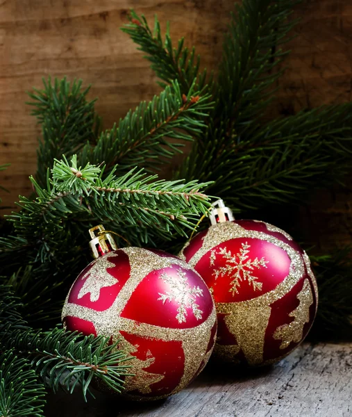 Two red and gold Christmas balls and spruce branches — Stock Photo, Image