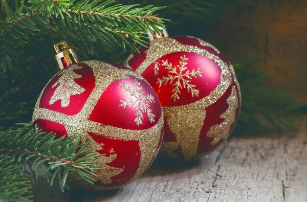 Dvě červené a zlaté vánoční koule a smrkové větve — Stock fotografie
