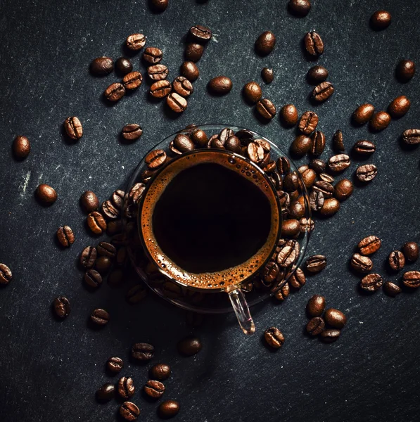 Glass cup of espresso coffee with foam, roasted coffee beans — Stock Photo, Image