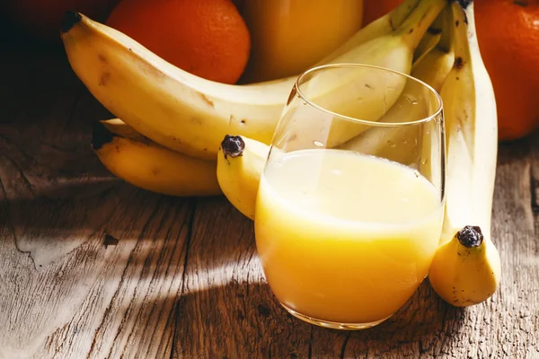 Banaan en sinaasappelsap in een groot glas — Stockfoto