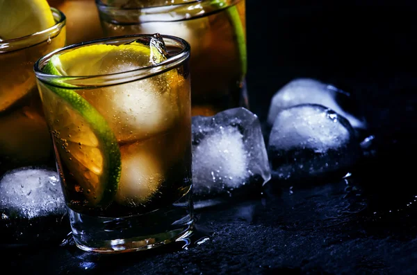 Alcoholic cocktail rum cola with ice, lime, lemon, cola and white rum