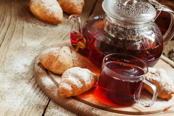 Café da manhã tradicional com chá preto e croissants — Fotografia de Stock