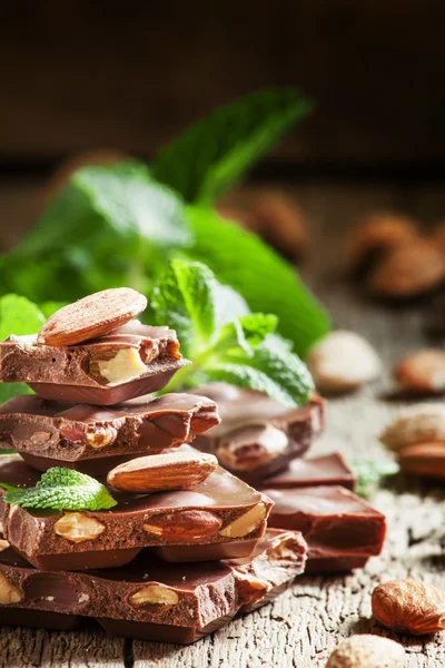 Вкусный молочный шоколад с миндалем и мятными листьями — стоковое фото