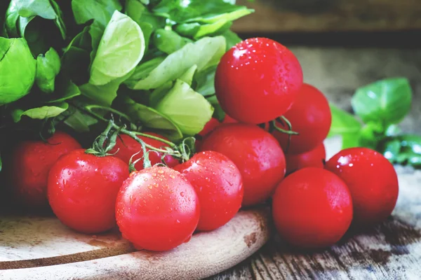 Tomates cherry, albahaca verde, fondo de madera —  Fotos de Stock