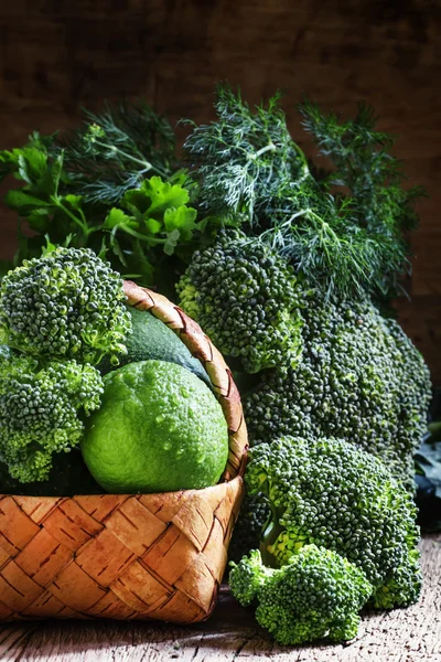 Плетеная корзина с зелеными овощами, фруктами и травами — стоковое фото