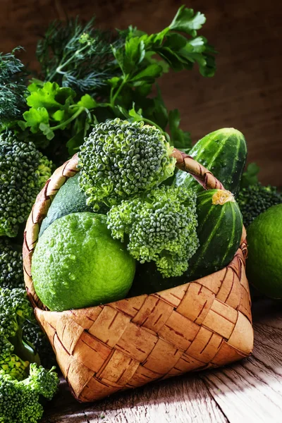 Wicker basket with green vegetables, fruits and herbs — Stock Photo, Image