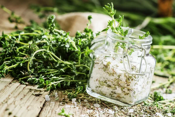 Traditional spicy salt with thyme in a glass jar — Stock Photo, Image