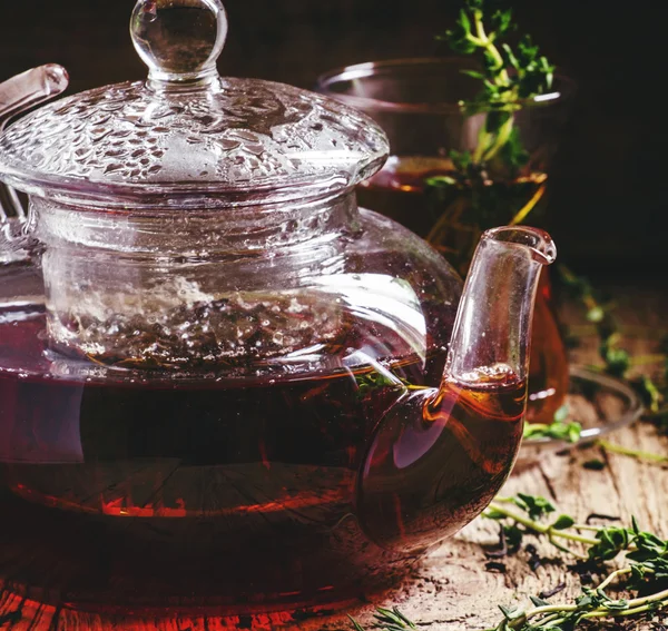 Стеклянный чайник с черным чаем с тимьяном — стоковое фото