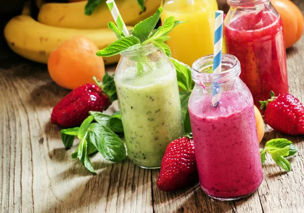 Garrafas multicoloridas com smoothies de frutas frescas — Fotografia de Stock