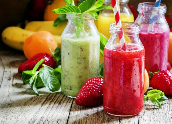 Garrafas multicoloridas com smoothies de frutas frescas — Fotografia de Stock