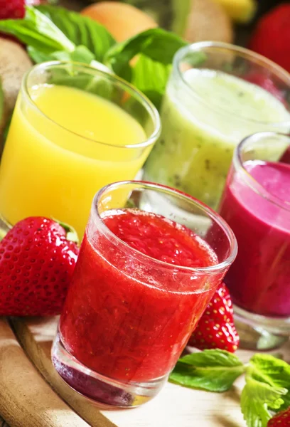Sumos de frutas e bagas coloridos de verão e smoothies em óculos — Fotografia de Stock