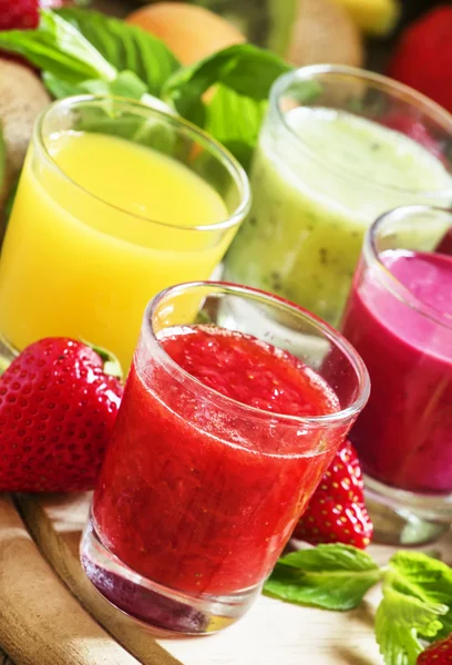 Coloridos jugos y batidos de frutas y bayas de verano en vasos —  Fotos de Stock