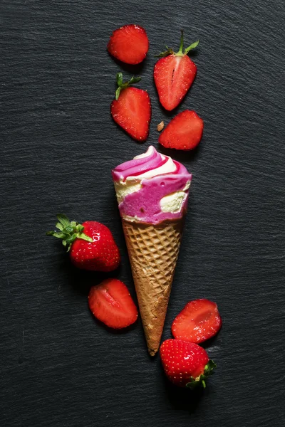 Gelado rosa em um cone de waffle com morangos frescos — Fotografia de Stock