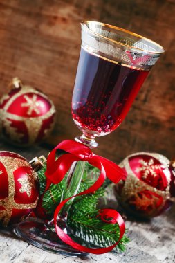 Kırmızı köpüklü şarap cam, ağaç dalları ve Noel topları 