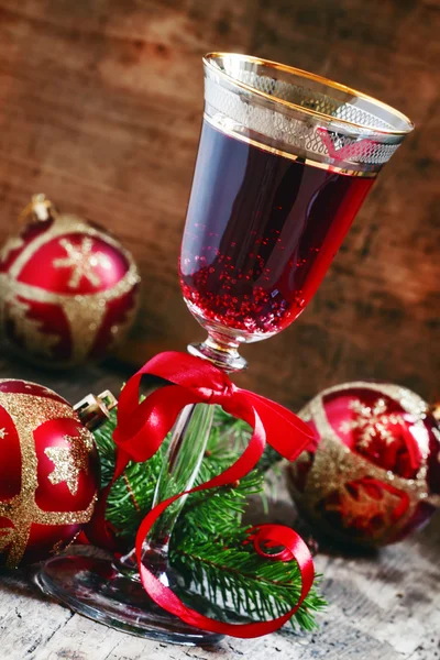 Красное игристое вино в стакане, ветви елки и рождественские шары — стоковое фото