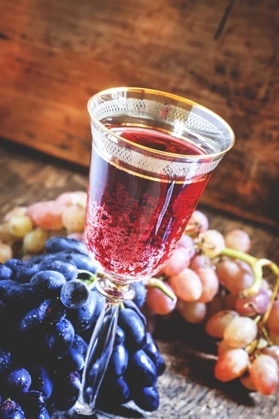 Vino espumoso tinto en copa, uvas azules y rosadas — Foto de Stock
