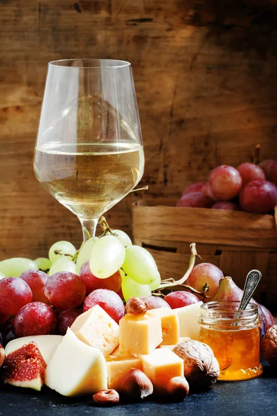 Vino blanco, queso, higos, frutos secos y uvas — Foto de Stock