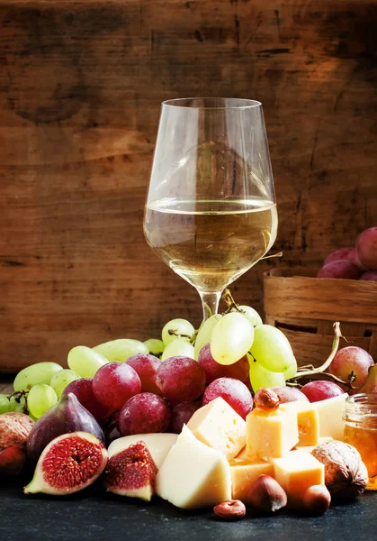 Vino blanco, queso, higos, frutos secos y uvas — Foto de Stock
